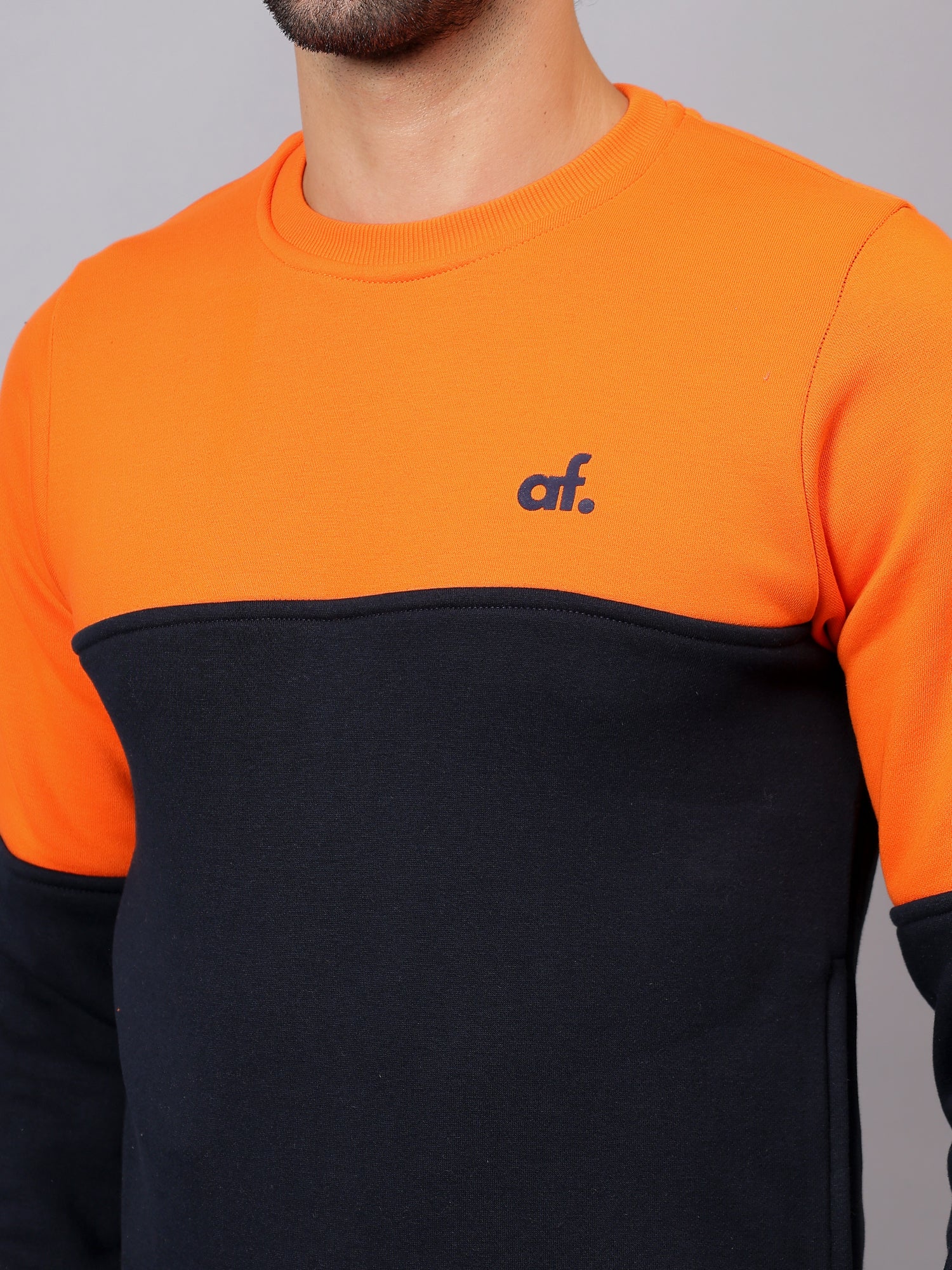Close view of ribbed neckline and premium stitching on Athfuel Merge two-tone sweatshirt in Orange-NavyBlue